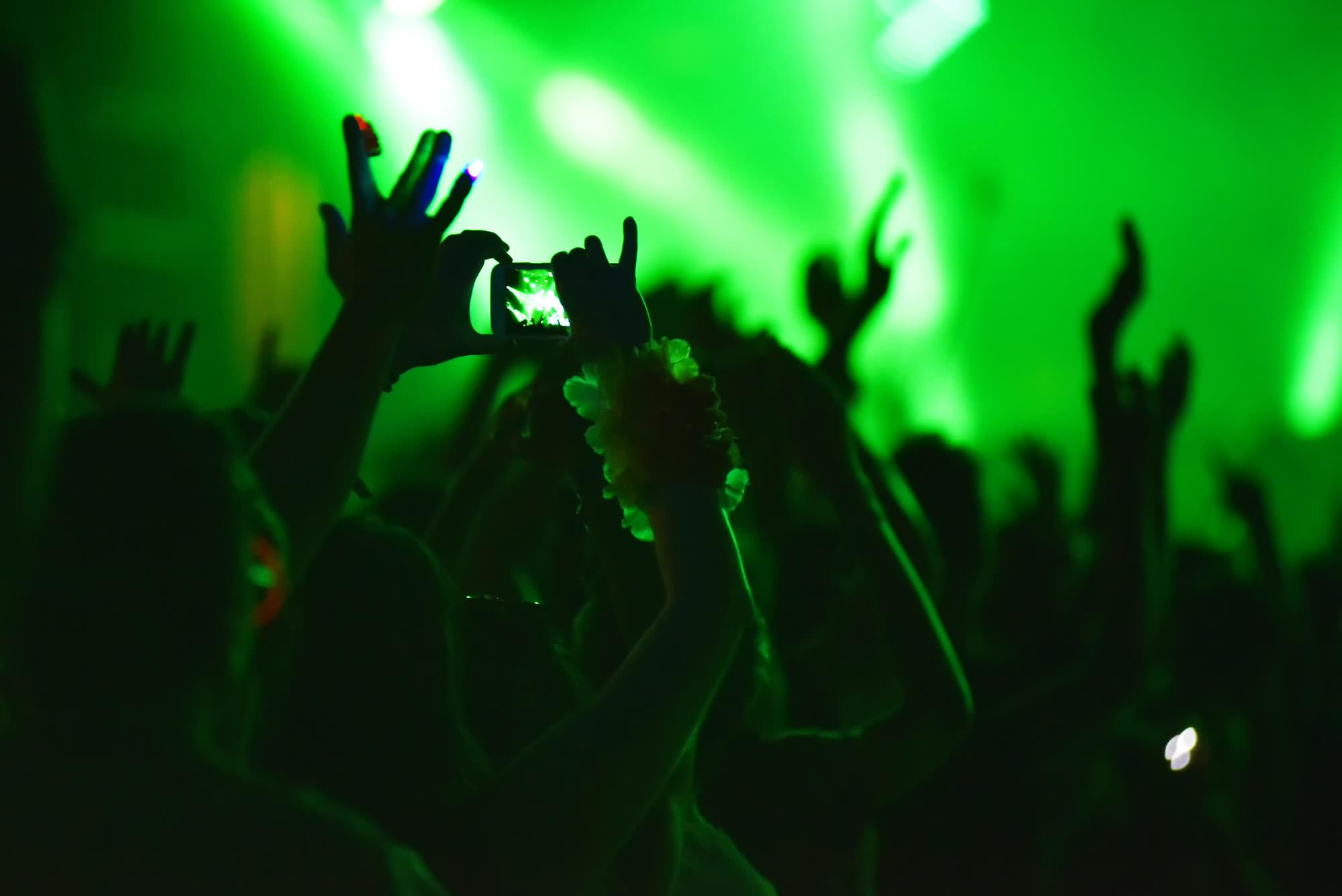 A crowd under green stage light