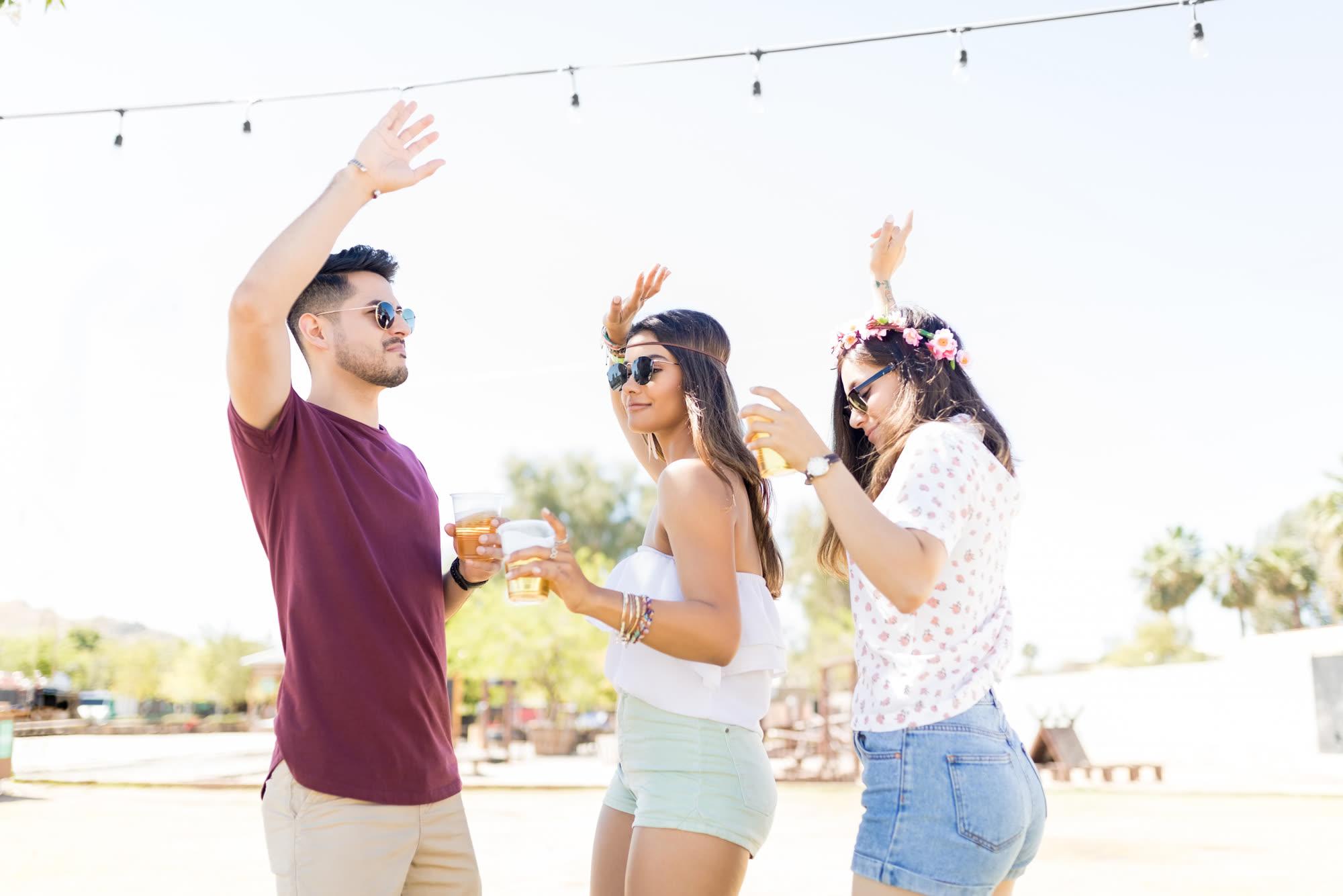 Friends dancing together outdoors at a live event